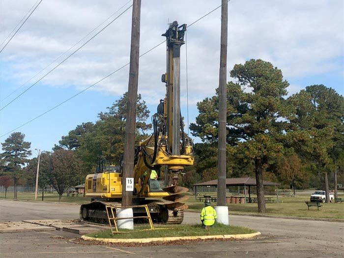 Worker kneeling in front of large drill equipment